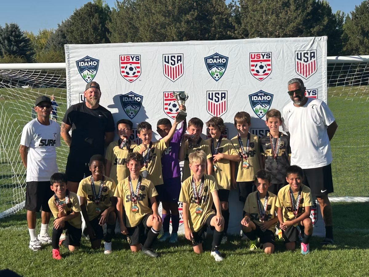 Idaho Surf U10 Academy players and coaches celebrating with their trophy and medals at the 2026 Gem State Challenge.